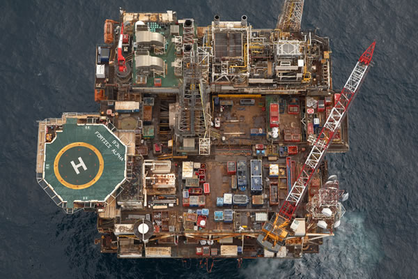 Aerial view of an offshore oil platform with equipment and a helipad