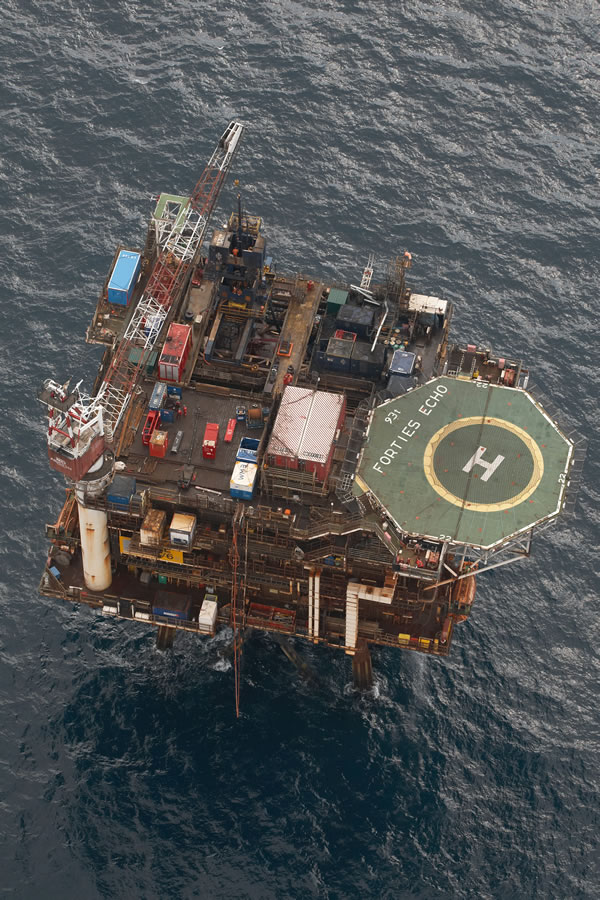 Aerial view of an offshore oil platform with equipment and a helipad