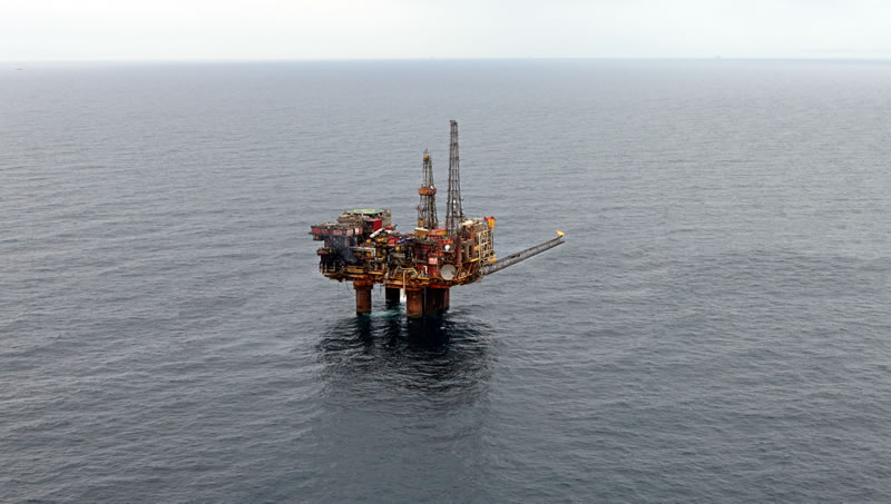 Aerial view of an offshore oil platform with equipment and a helipad